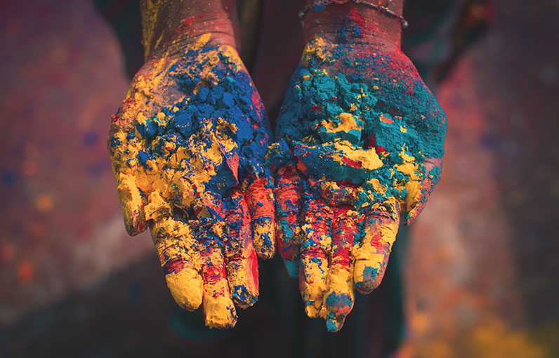 close up of a pair of hands holding powdered color that's used in the Holi festival in India
